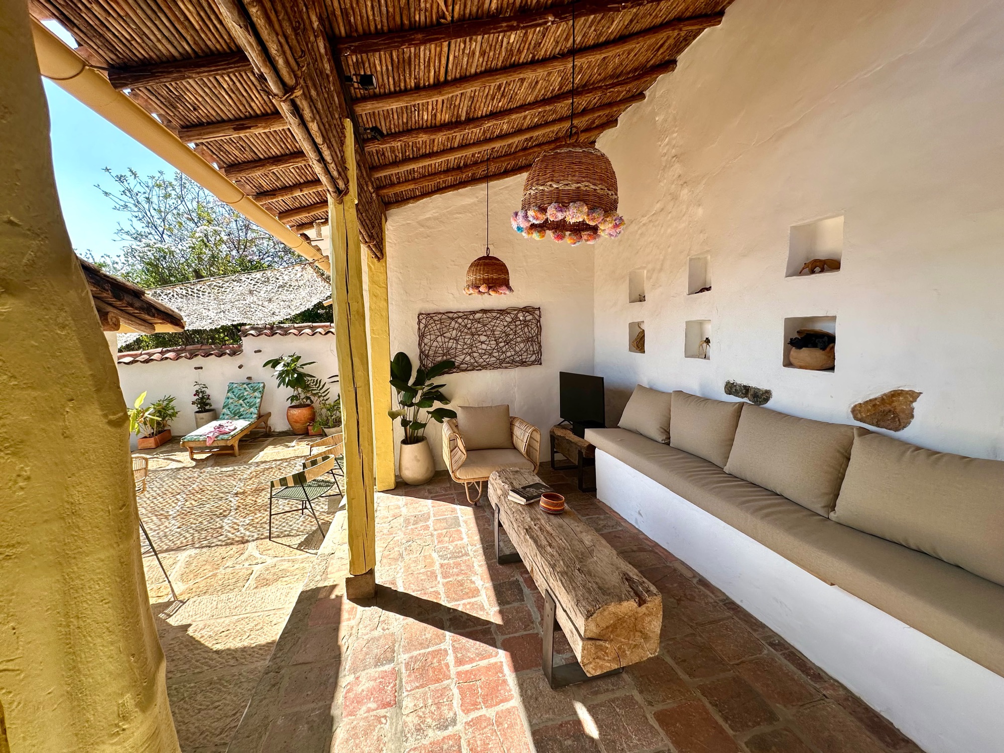 Terraza cubierta con estructura en madera y caña
