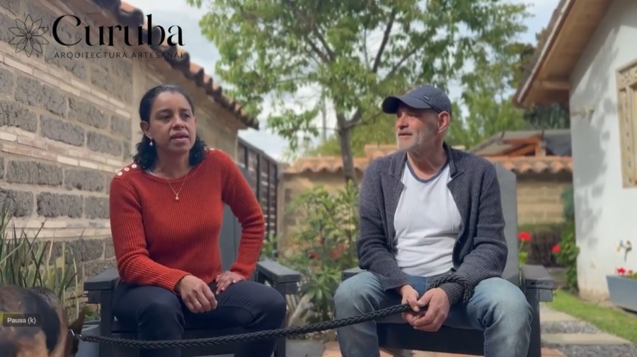 Pareja de clientes frente a su casa en piedra