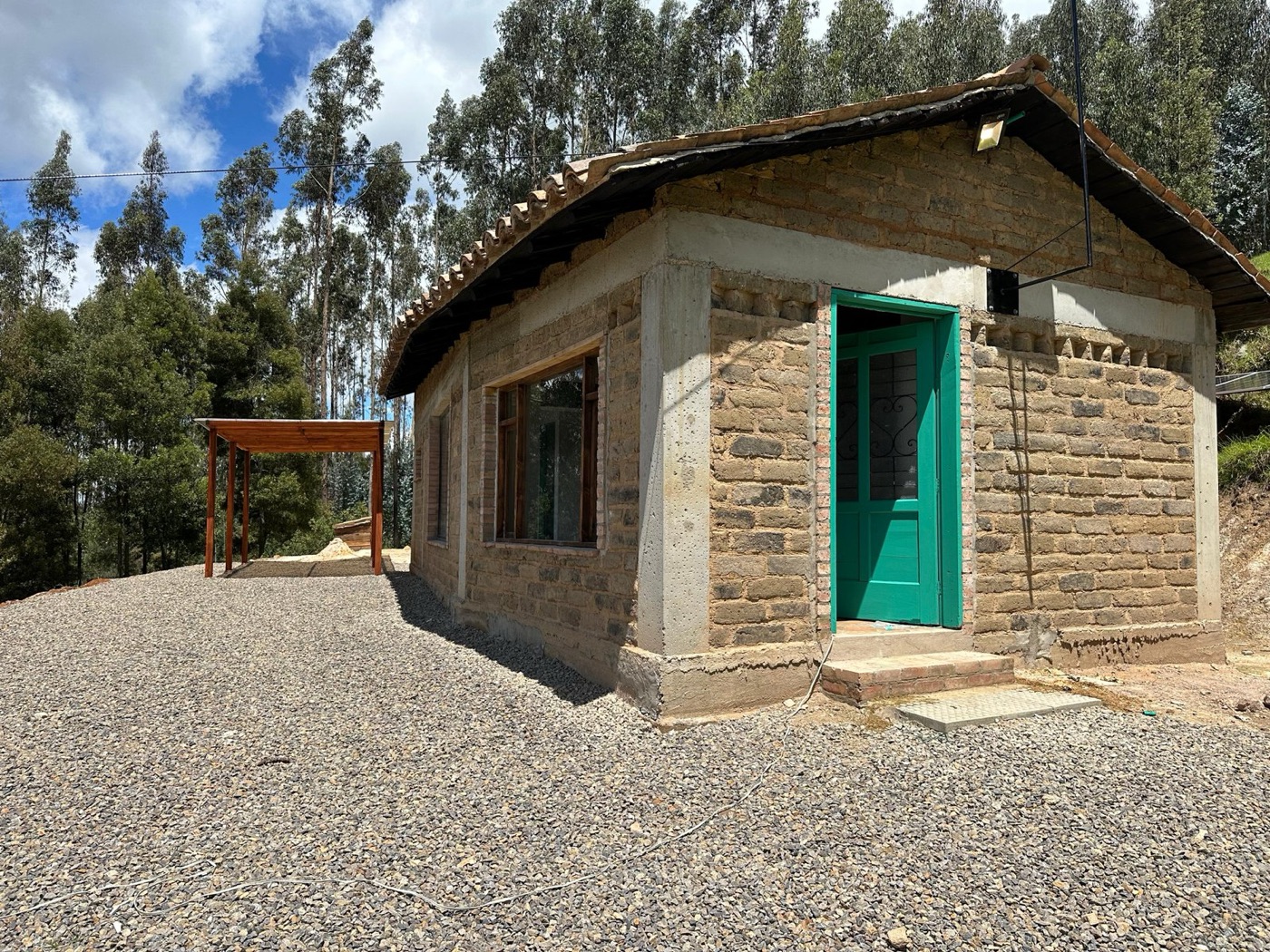 Casa en piedra con puerta verde y cubierta en teja de barro